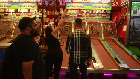 A-couple-plays-a-skee-ball-arcade-game-during-a-fun-evening-out-at-a-carnival