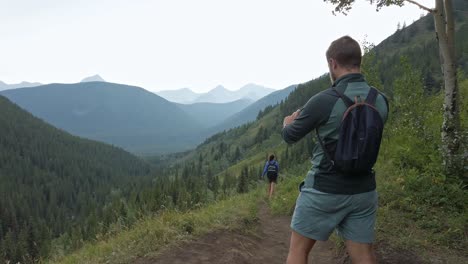 Hikers-photographing-walking-downhill-on-a-trail-in-high-altitude-Rockies-Kananaskis-Alberta-Canada