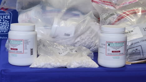 A-close-up-dolly-shot-of-bottles-of-Teva-Oxycodone-and-other-narcotics-seized-as-evidence-during-a-drug-bust-by-Peel-Regional-Police-after-investigating-a-syndicate-operating-in-Mississauga,-Canada