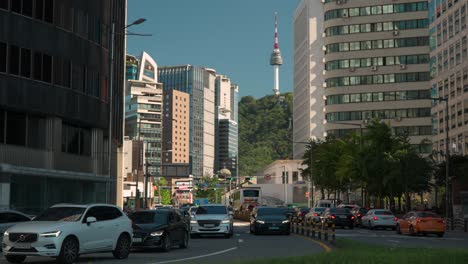 Heavy-traffic-jam-in-Seoul-downtown-near-City-Hall-on-Sogong-ro-road,-N-Seoul-Tower-distant-view-behind-High-office-buildings-on-a-summer-day