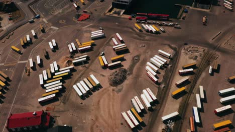 Aerial-view-overlooking-cargo-wagons-and-ferries-at-a-shipping-terminal,-in-sunny-Finland