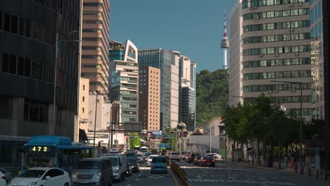 View-of-N-Seoul-Namsan-Tower-from-downtown-city-streets-with-high-rise-office-buildings-and-traffic-on-Sogong-ro-road