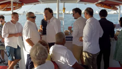 Wedding-guests-all-talking-to-each-other-on-a-catamaran-sail-boat-tour-from-Grand-Motte-to-Montpellier,-Southern-France