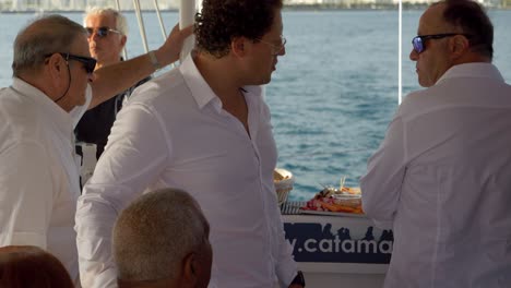 Groom-walking-through-his-wedding-party-talking-to-his-guests-on-a-sail-boat