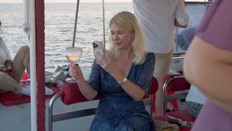 Schöne-Frau,-Die-Ein-Foto-Von-Einem-Weinglas-Auf-Einem-Katamaran-Segelboot-Macht