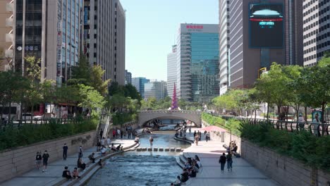 Seoul-City-Ambiance-at-Cheonggyecheon-Stream-Park---People-Relaxing-on-Summer-Day-in-Downtown,-South-Korea