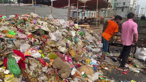 Municipal-workers-clear-waste-at-roadside-landfill-from-van