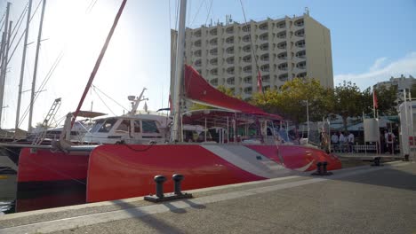 Barco-De-Vela-Catamarán-Rojo-Anclado-En-El-Puerto-De-Grande-Motte,-Sur-De-Francia