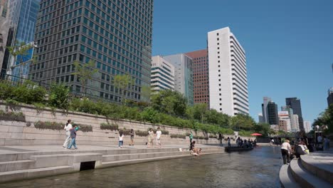 Korean-People-Walking-by-Cheonggyecheon-Stream-Relaxing-on-Summer-Sunny-Day-in-Seoul-City,-South-Korea