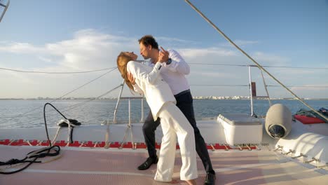 Wedding-couple-kissing-on-a-catamaran-sailing-boat