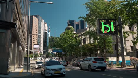Seoul-Belebte-Sogong-ro-Straße-Mit-Autoverkehr-Und-Blick-Auf-N-Seoul-Tower,-Pov-Von-Einem-Bürgersteig