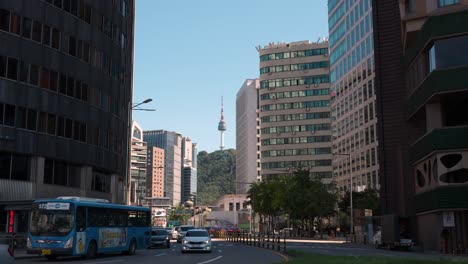 View-of-N-Seoul-Namsan-Tower-from-downtown-city-streets-with-high-rise-office-buildings-and-traffic-on-Sogong-ro-road