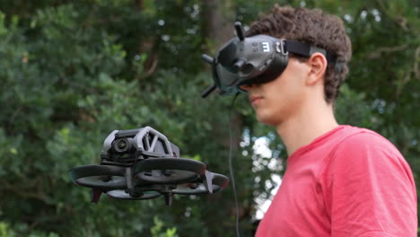 Man-With-Goggles-Headset-and-DJ-Avata-FPV-Drone-Hovering-in-Front,-Close-Up