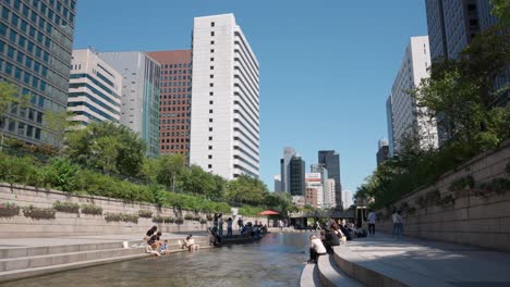 Cheonggyecheon-in-Seoul-with-people-resting-waterfront-stream