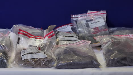 Close-pan-of-drugs-seized-by-Canadian-PRP-police-in-plastic-bags-on-table