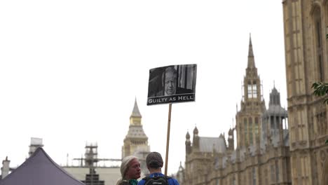 Demonstrant-Mit-Plakat-Mit-Foto-Von-Boris-Johnson-Hinter-Gittern-Vor-Dem-Parlament