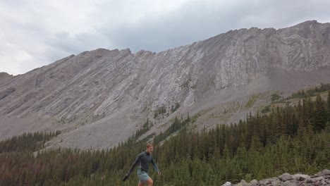 Hiker-walking-up-mountain-buy-forest-followed-tilt-Rockies-Kananaskis-Alberta-Canada