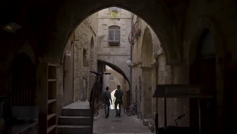 JERUSALEM,-ISRAEL---September-2,-2022:-walking-down-the-Via-Dolorosa,-a-processional-route-in-the-Old-City,-with-tourists-in-the-background