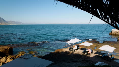 Tourists-at-Bientang's-Cave-restaurant-on-the-rocks-whale-watching,-Hermanus