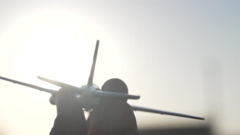 Detail-Des-Kindes,-Das-Während-Des-Sonnenuntergangs-Ein-Kleines-Spielzeugflugzeug-Hält