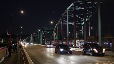 Traffic-on-Dongjak-bridge-at-night-and-people-enjoying-Seoul-panoramic-city-view,-South-Korea