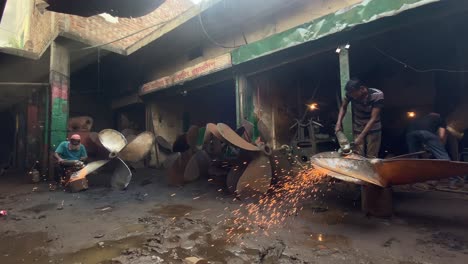 Stahlarbeiter-Schärfen-Schiffspropeller-Mit-Winkelschleifer-In-Einer-Dock-Werkstatt-In-Bangladesch