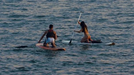 SUP-boarding-in-Brasilia,-Brazil,-couple-using-boards-in-lake-paranoa