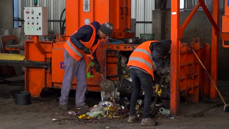Workers-throw-garbage-into-a-waste-compacter