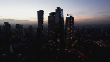 Aerial-view-of-skyscrapers-in-the-Cuauhtemoc-district,-sunrise-in-Mexico-city---ascending,-drone-shot