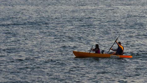 Daughter-and-father-time-together-rowing-yellow-boat-in-Lago-Paranoa,-Brazil
