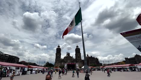 Aufnahme-Der-Mexikanischen-Flagge,-Die-Bei-Sonnenuntergang-Mit-Voller-Sicht-Auf-Den-Zocalo-Im-Hintergrund-Weht