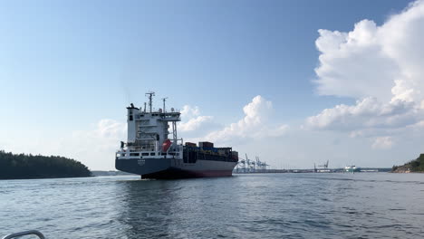 Frachtschiff-Mit-Gefilmten-Containern,-Die-An-Einem-Sonnigen-Tag-Von-Meereshöhe-In-Den-Hafen-Einlaufen