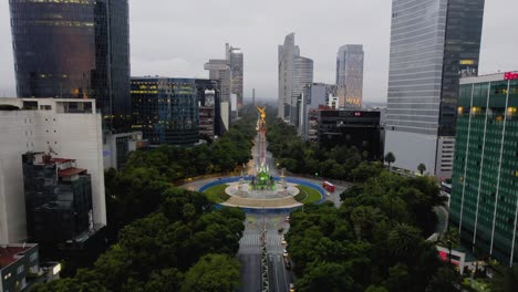 Aerial-view-over-the-Reforma-Avenue,-towards-the-Angel-of-Independence-statue-in-cloudy-Mexico-city