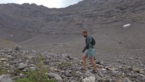 Hiker-walking-trough-mountain-amphitheatre-followed-circled-Rockies-Kananaskis-Alberta-Canada