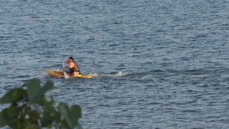 Man-rowing-kayak-in-harsh-wind-conditions-on-lago-Paranoa,-Brasilia,-Brazil