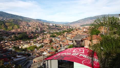 Zoom-Out-Valley-of-Comuna-13-Medellin-Colombia-Sun-Shines-Mountains-Brick-Houses