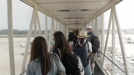 Blick-In-Die-Flugzeugbrücke,-Während-Viele-Menschen-In-Den-Sommerferien-In-Das-Flugzeug-Einsteigen
