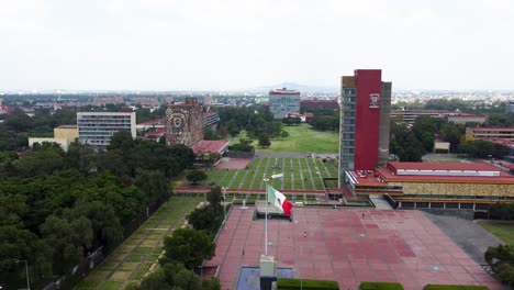 Front-view-of-central-university-city-campus-with-the-mexican-flag-waving