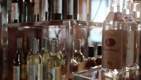 Wine-bottles-on-a-glass-shelf.-Gimbal-shot