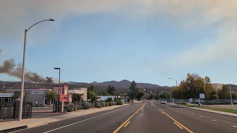 Driving-through-American-town-with-large-plumes-of-smoke-from-wildfire