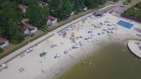 4k-drone-view-approaching-a-lake-beach-in-Nooitgedacht,-The-Netherlands