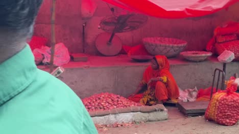 Bengalische-Frauen-Saßen-Neben-Haufen-Auf-Zwiebeln-Unter-Roter-Plane-Mit-Ventilator,-Der-Auf-Dem-Markt-In-Bangladesch-Bläst