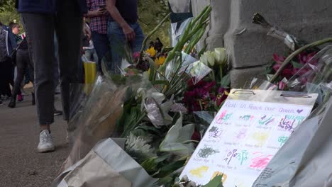 People-leave-flowers-at-a-memorial-to-the-Queen-at-the-entrance-to-St-James-Park-in-London,-UK