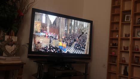 Household-watching-Her-Majesty-Queen-Elizabeth-ceremonial-funeral-service-broadcast-on-British-public-television-at-home