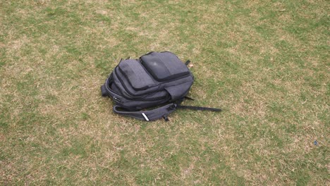 Grey-backpack-thrown-down-on-the-grass