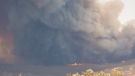 A-distant-shot-of-the-thick-black-cloud-of-smoke-coming-from-the-raging-Fairview-wildfire-as-it-burns-destroying-the-mountaintop-landscape,-Hemet,-California