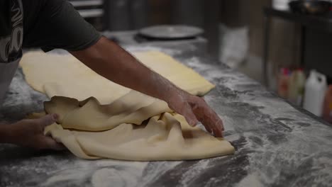 baker-preparing-dough-for-bread-and-pastry-making,-artisan-bakery,-baker-making-bread-and-pastry,-dough-kneading