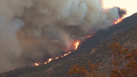 Billowing-smoke-and-raging-flames-of-the-Fairview-wildfire-moving-across-the-dry-mountainous-landscape-of-Hemet,-California
