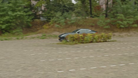 Green-jaguar-F-Type-sports-car-slowly-leaving-parking-lot-and-accelerating-fast