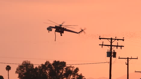 Silueta-De-Un-Helicóptero-De-Extinción-De-Incendios-Que-Vuela-Contra-El-Cielo-Sombrío-Cerca-Del-Rancho-Gless